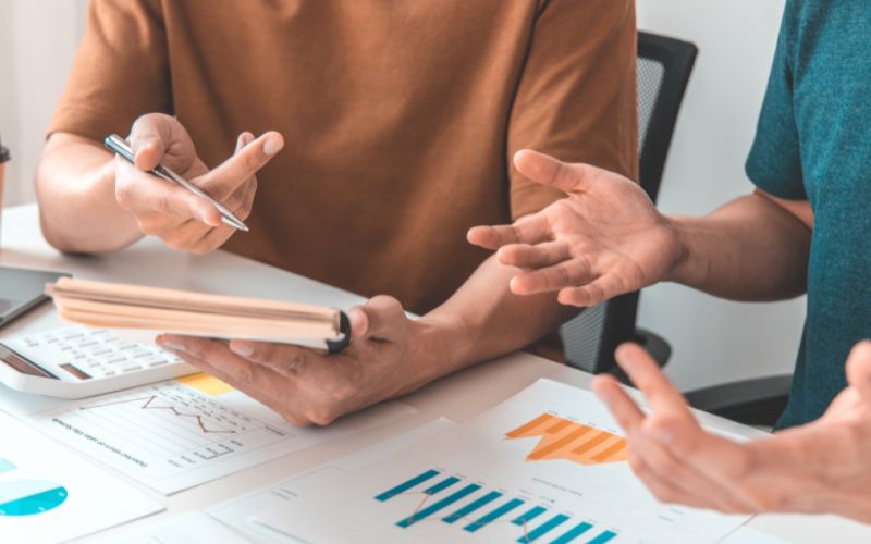 Personas revisan gráficos y discuten cómo una idea puede convertirse en un modelo de negocio viable.