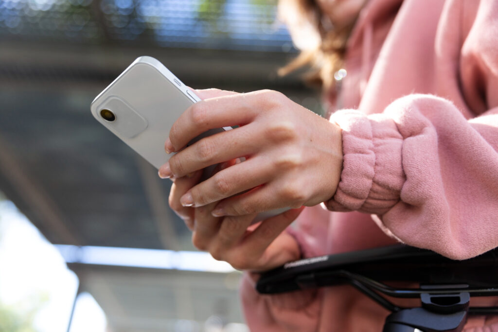Manos femeninas manipulan un teléfono celular, para ilustrar los tipos de empresas unicornio que han innovado con apps móviles.