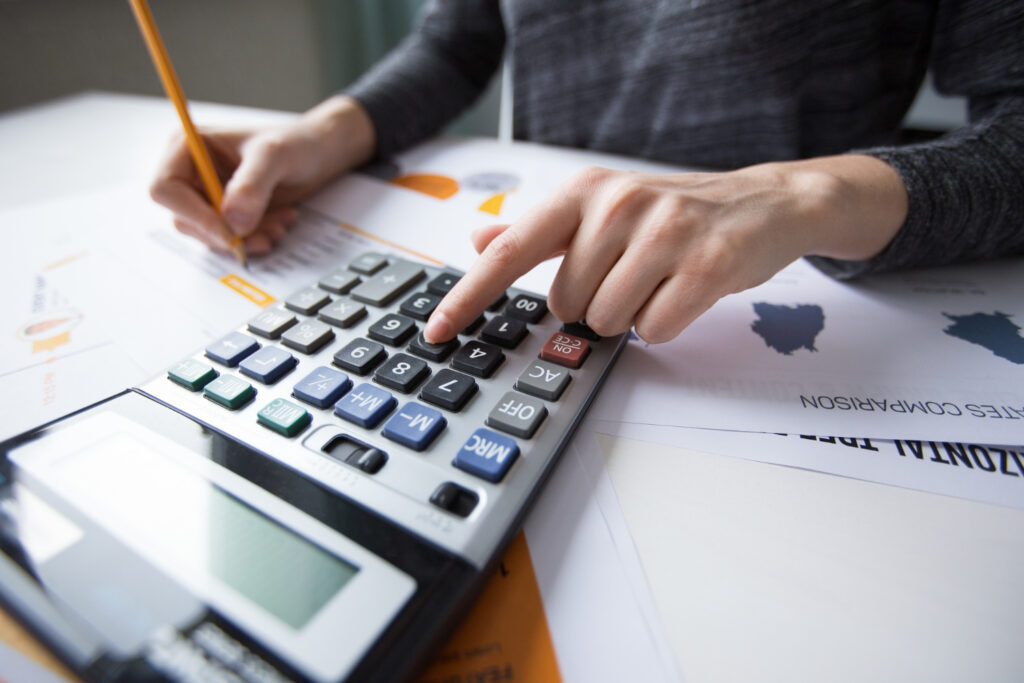 Una persona usa una calculadora para verificar registros contables en su empresa.