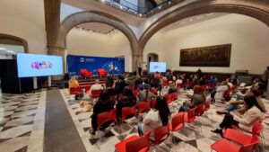 Salón lleno de personas que ponen atención a ponentes en la graduación de emprendedores con discapacidad.