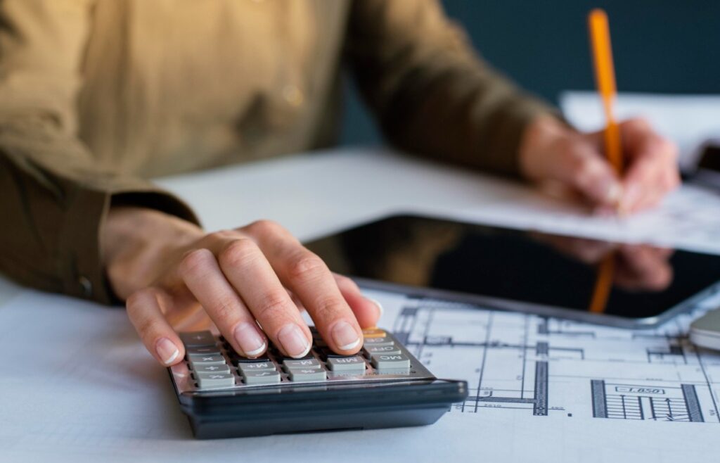 Vista de las manos de una mujer que calcula sus impuestos. La imagen ilustra el cumplimiento de las obligaciones fiscales.