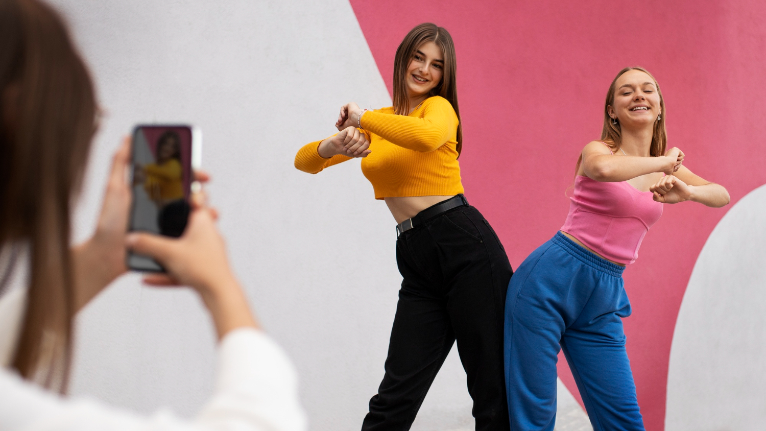 Mujeres bailan una coreografía mientras otra las graba con un teléfono celular. La imagen ilustra los contenidos que se suben a TikTok