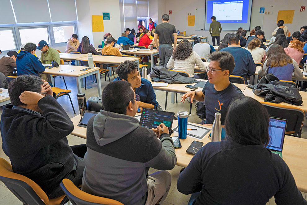 Personas organizadas en grupos de trabajo discuten ciertos temas dentro del campamento de emprendimiento organizado por la UNAM.