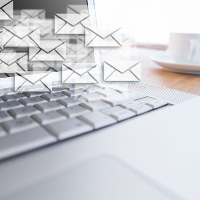 Varias plataformas de email marketing ejecutan envíos masivos desde una laptop.